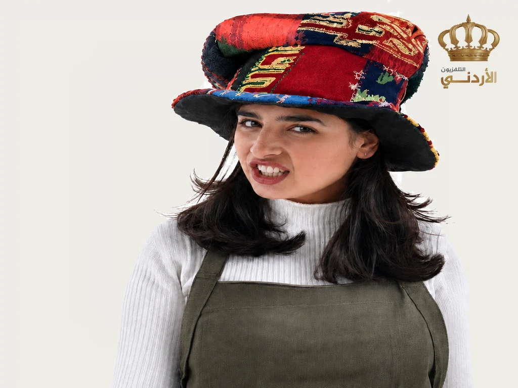 Aroub Soubh in the 1990s in Waqt Al Farah's patchwork hat, pulling a face at the camera, the Jordan Television crown in the corner of the screen.